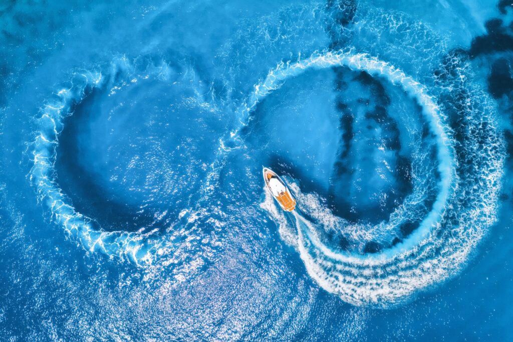 Aerial view of the speed boat in clear blue water at sunny day